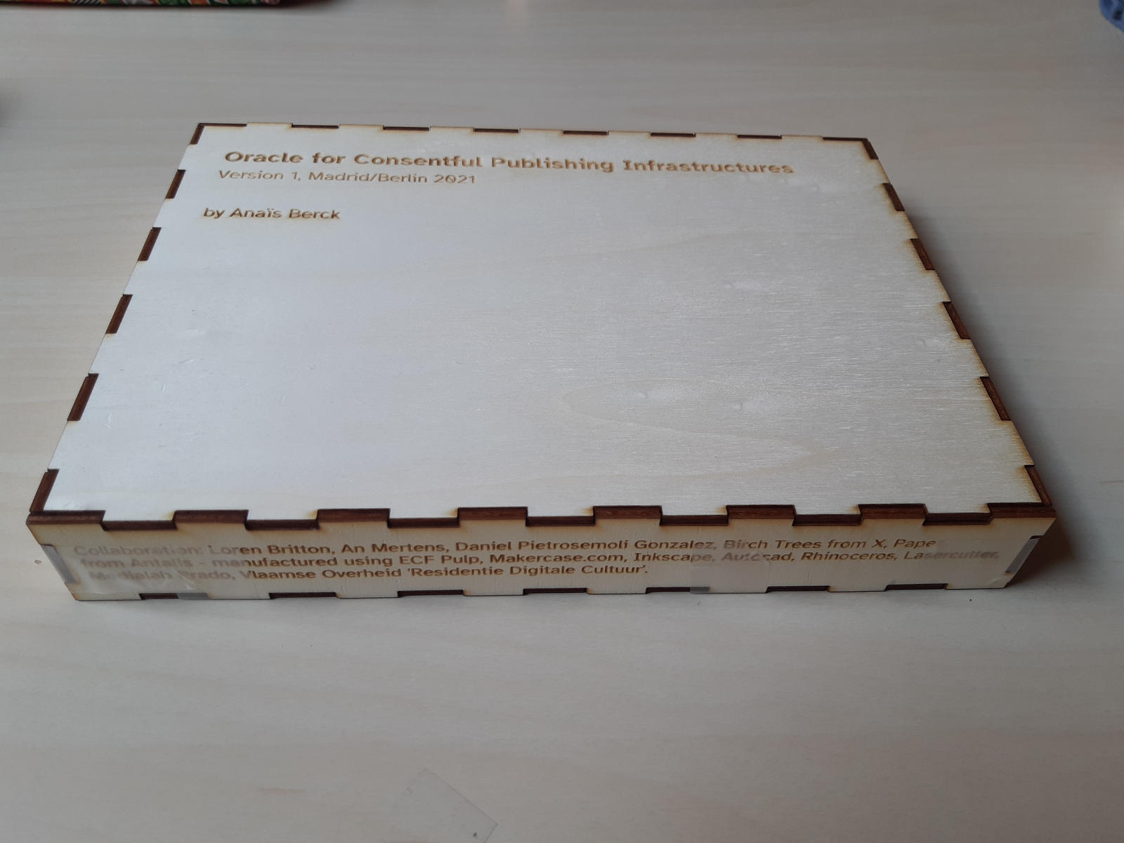 A wooden box is shown. Wood burned onto it are the words ‘Oracle for Consentful Publishing Infrastructures’